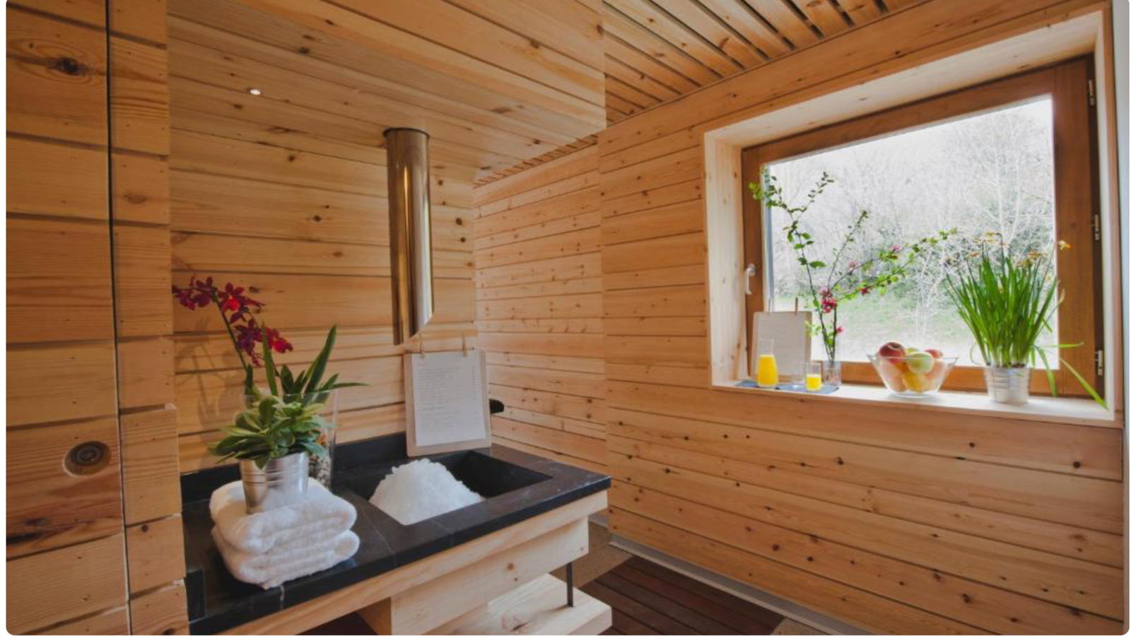 Baño revestido de madera con ventana al exterior